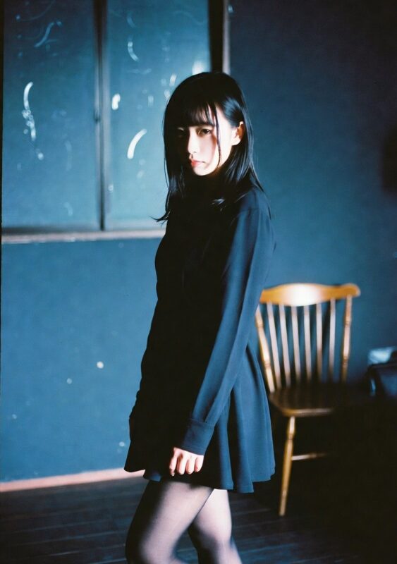 青く薄暗い部屋に佇む黒パンストの女性